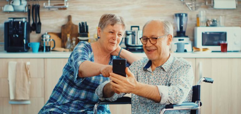 Un proche aide son aîné à utiliser un moyen de téléassistance